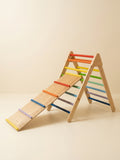 Wooden A-frame Pikler triangle paired with long bars ramp of rainbow colors theme.